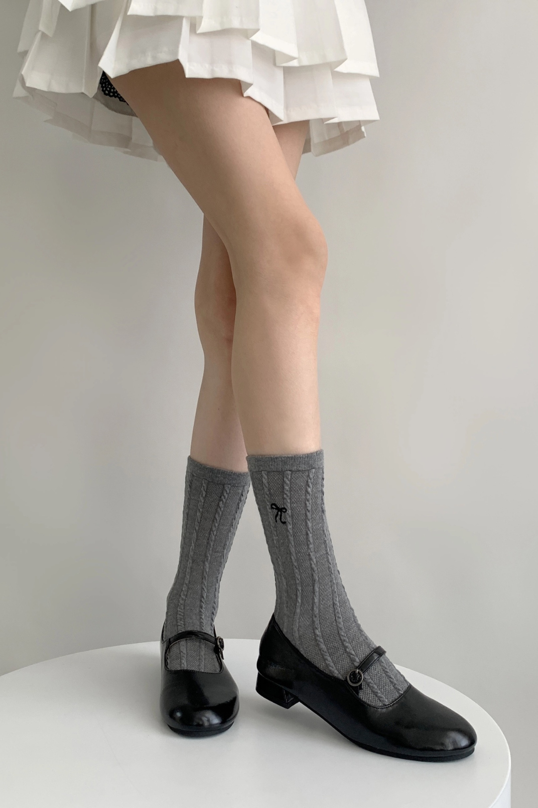 Model viewing textured Bow Socks in the grey color in a standing position.