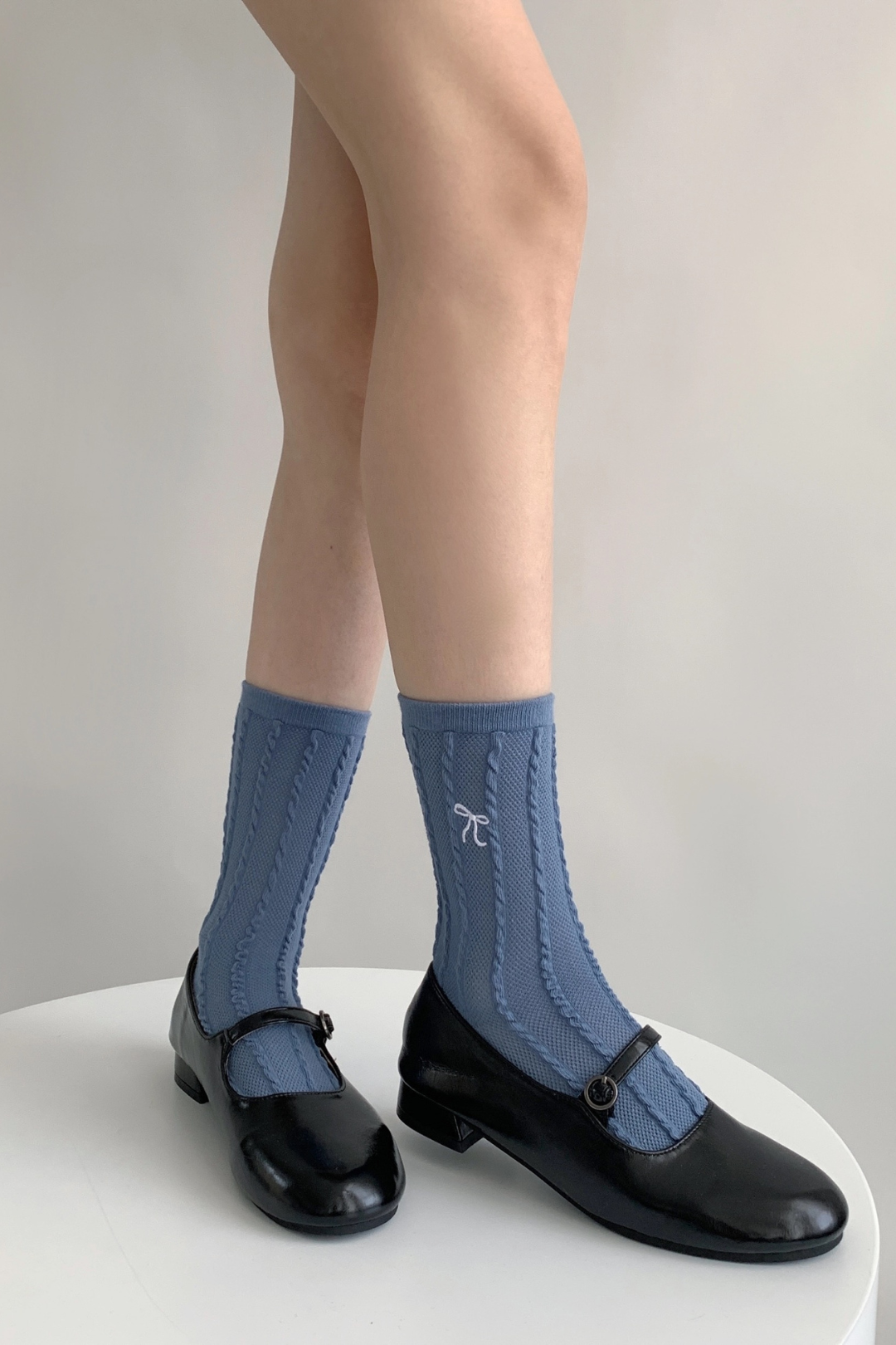 Model wearing textured Bow Socks in the blue color in a standing position. 