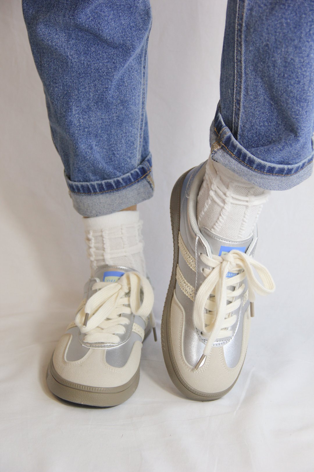 Model wearing Essen Silver Metallic Sneakers, front view.