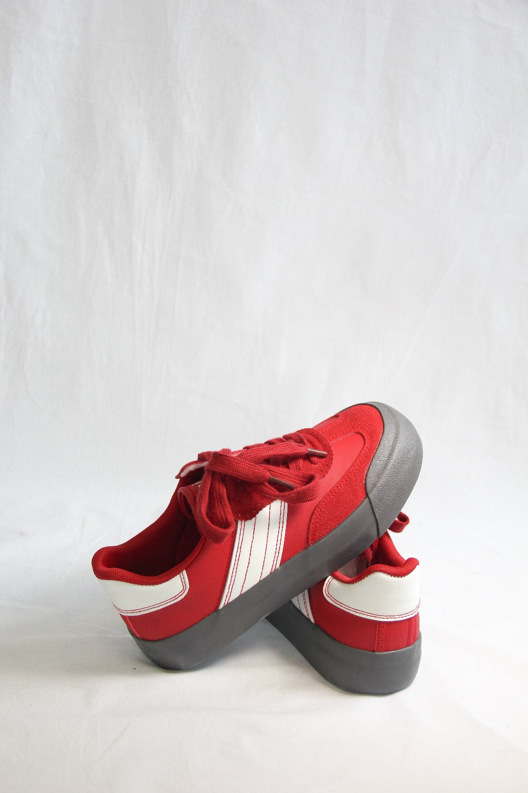 Product view of Jena Red Sneakers, one shoe diagonally placed on top of another.  view.