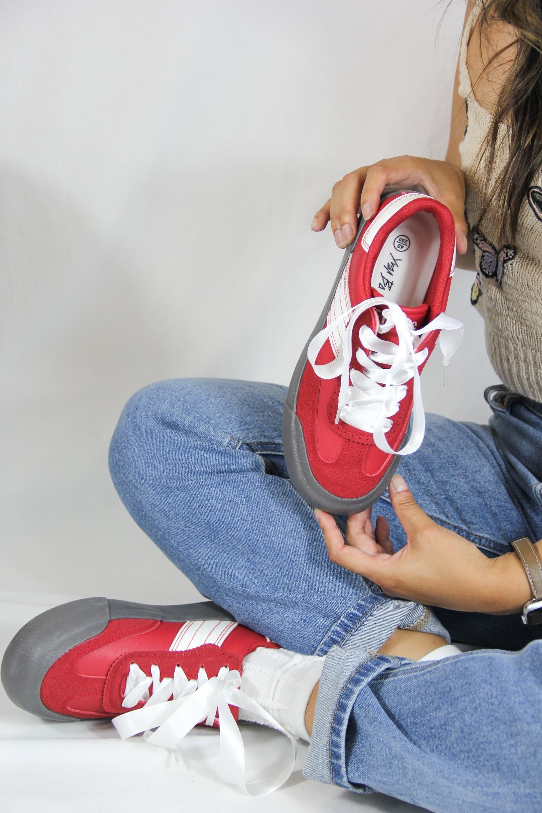 Model holding Jena Red Platform Sneakers with White Satin Shoelaces